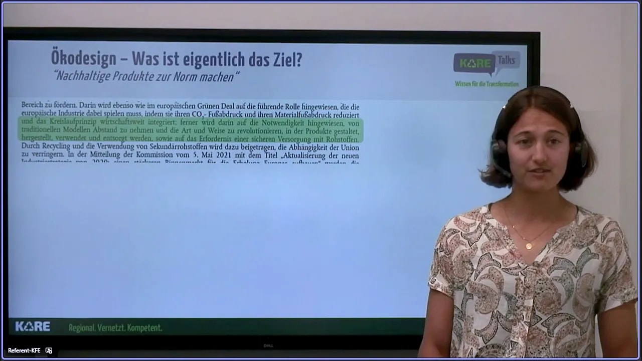 Referentin steht neben einer Präsentationsfolie mit der Überschrift 'Ökodesign - Was ist eigentlich das Ziel?'